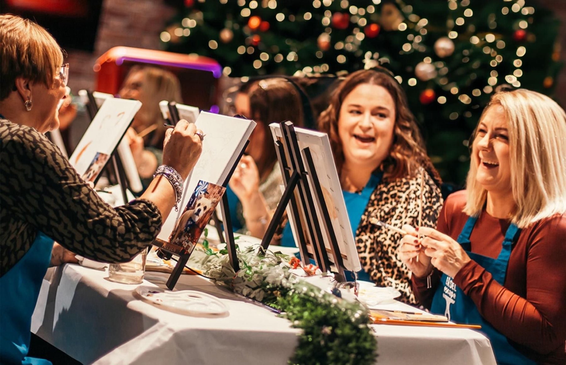 A Christmas paint night in Belfast, easels in a row under fairy lights