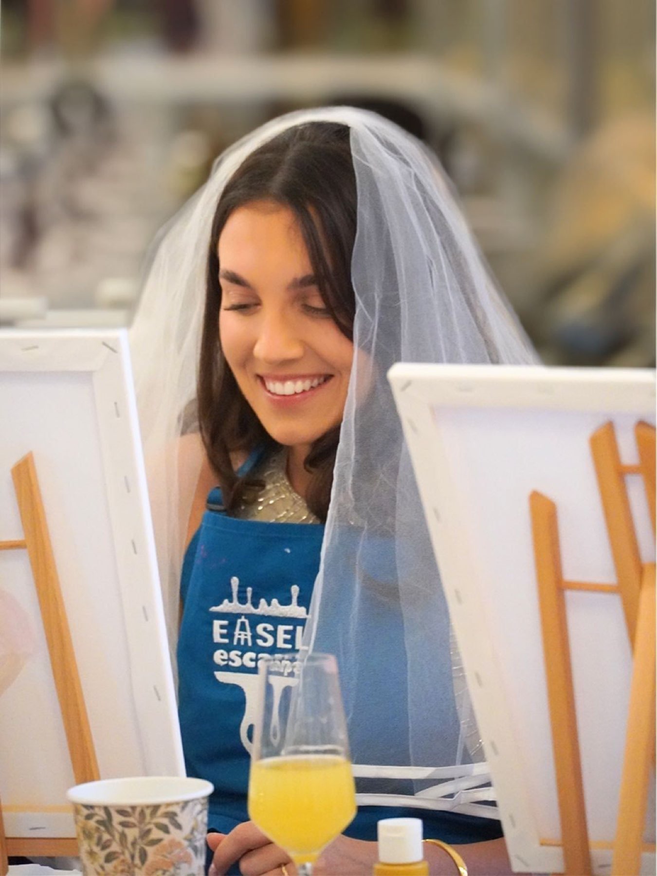 A bride in a veil painting at her easel