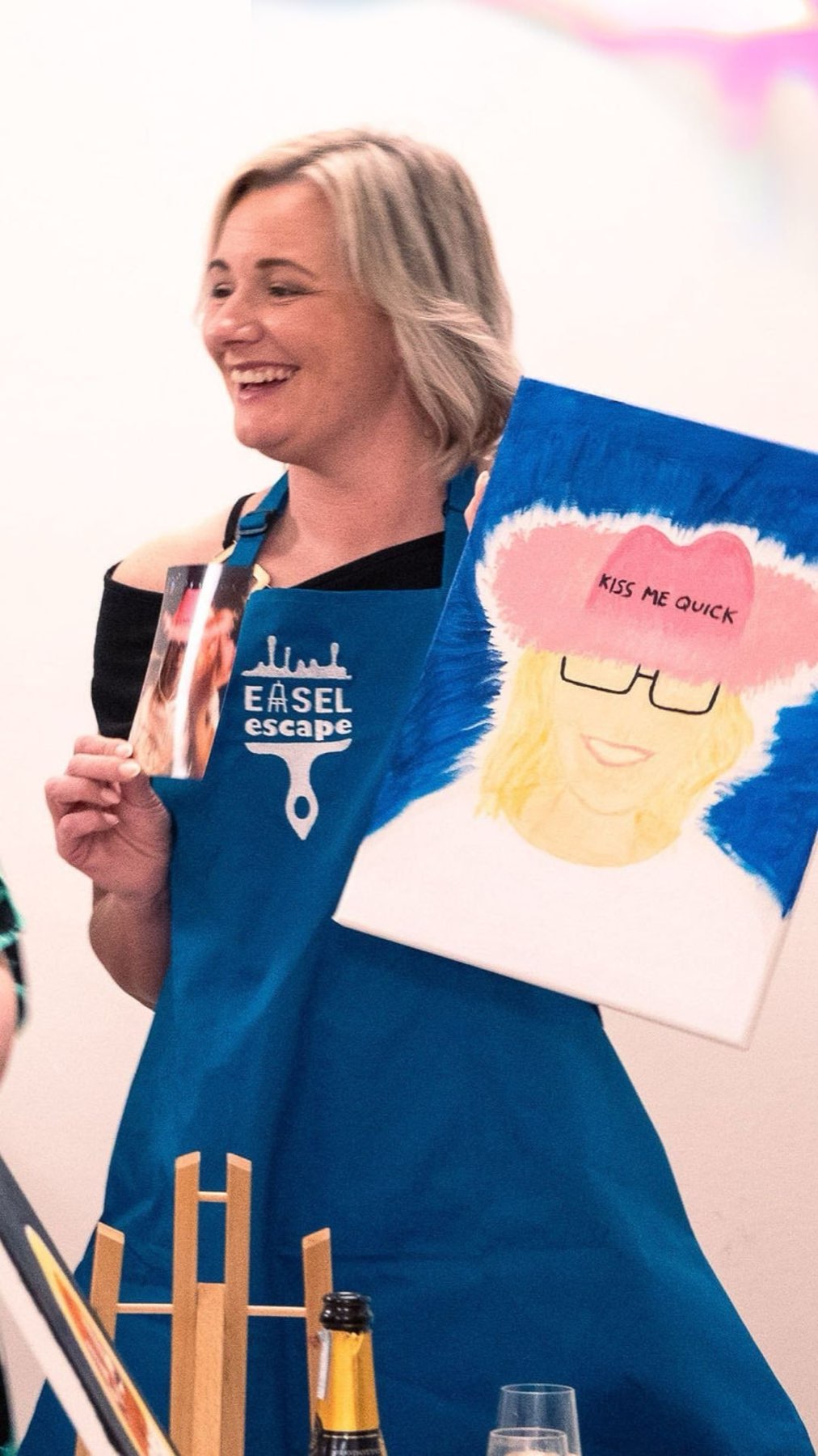 A laughing guest holding up her Kiss Me Quick portrait at a Belfast hen party