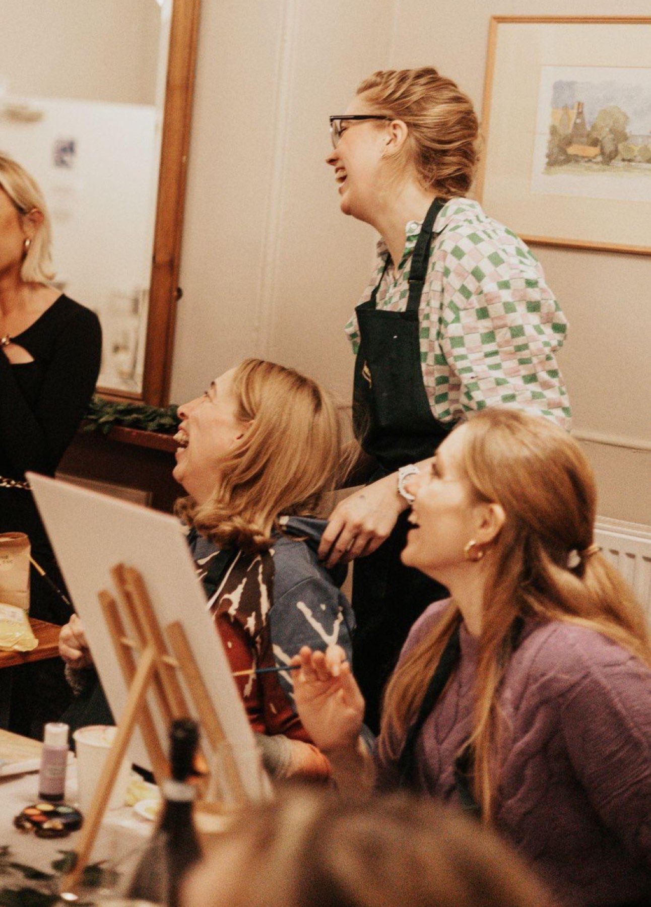 Three painters laughing together at their easels