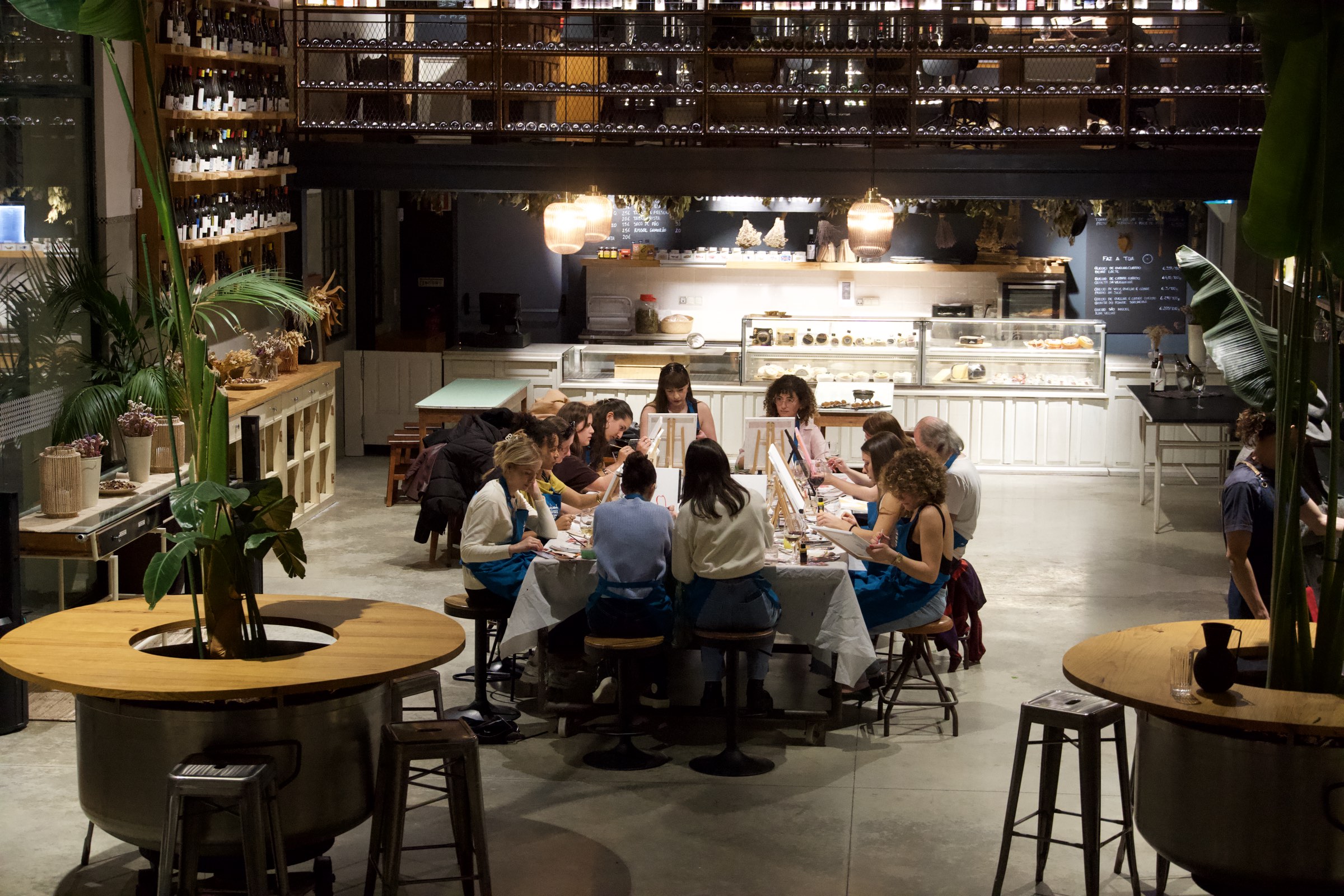 A long table of painters filling a stylish Lisbon venue